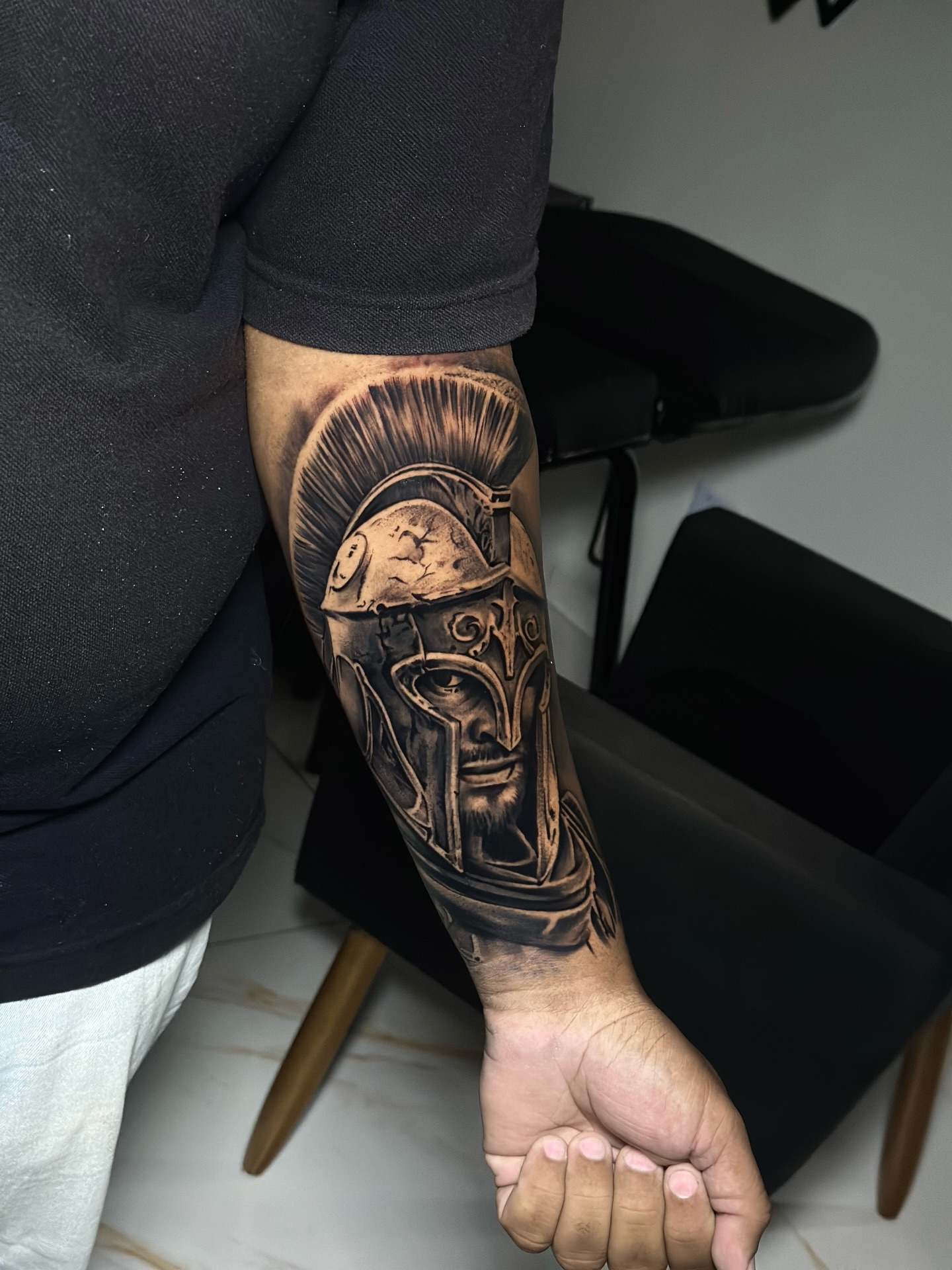 Tatuagem realista de capacete espartano no antebraço