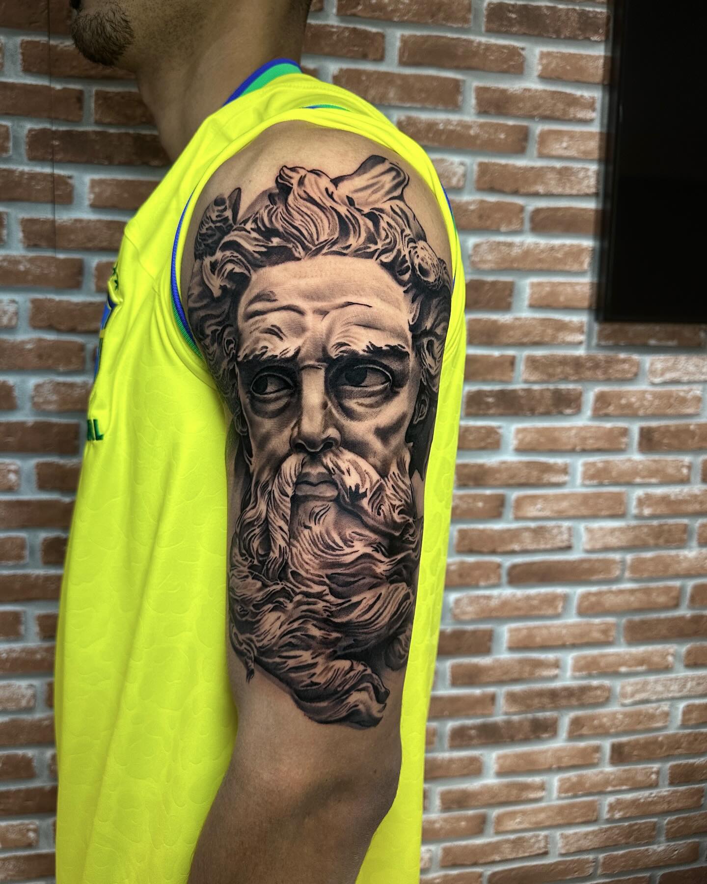 Tatuagem realista de estátua de Zeus no braço